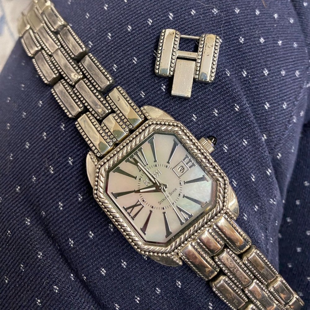 Sterling silver watch with white face. Brand is ECCLISSI. Has extension.